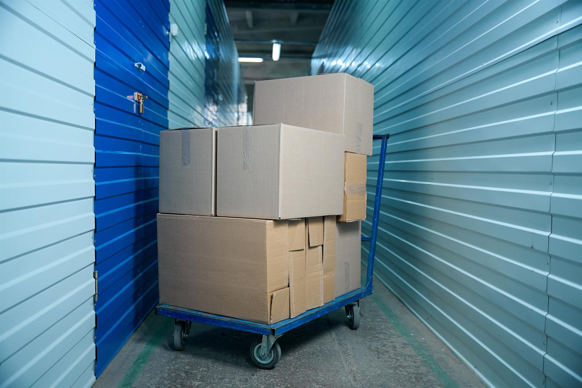 Boxes stacked on a cart inside a StorCo storage unit